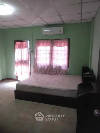 Cozy bedroom with air conditioning and natural light, perfect for relaxation.