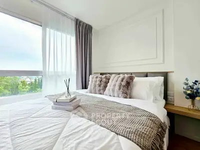 Bright and cozy bedroom with large window and stylish decor