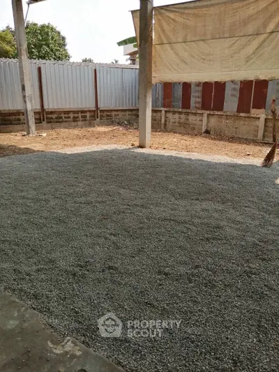 Vacant plot with gravel surface, ideal for construction or development opportunities.