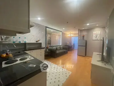 Spacious open-plan living room and kitchen with modern decor and hardwood floors.