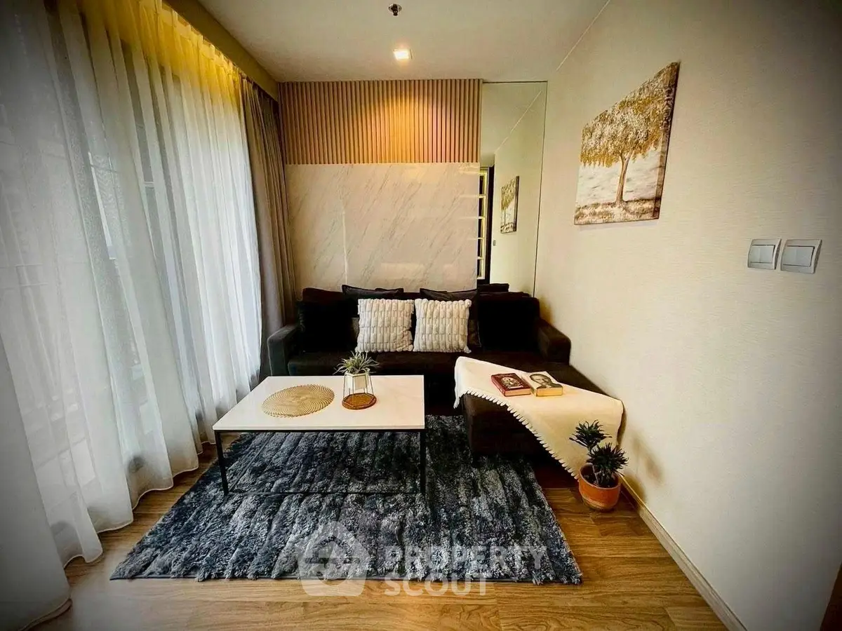 Cozy living room with modern decor, plush sofa, and large window for natural light.
