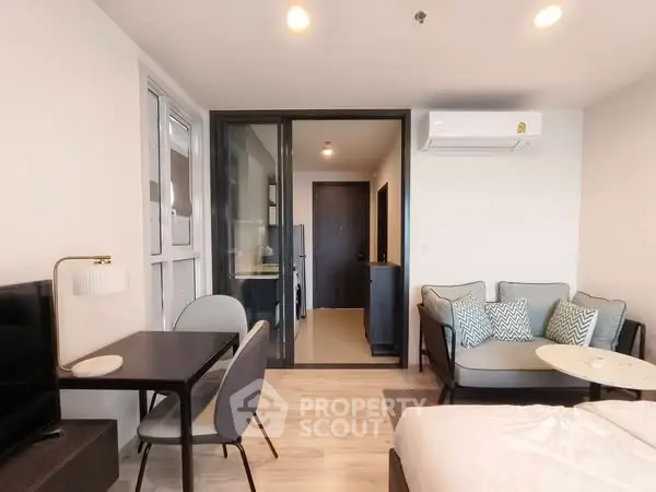 Modern studio apartment with cozy living area and sleek furniture