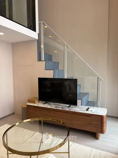 Modern living room with stylish staircase and sleek TV stand, perfect for contemporary urban living.
