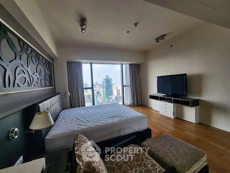 Luxurious bedroom with stunning city view, modern decor, and large windows in high-rise apartment.