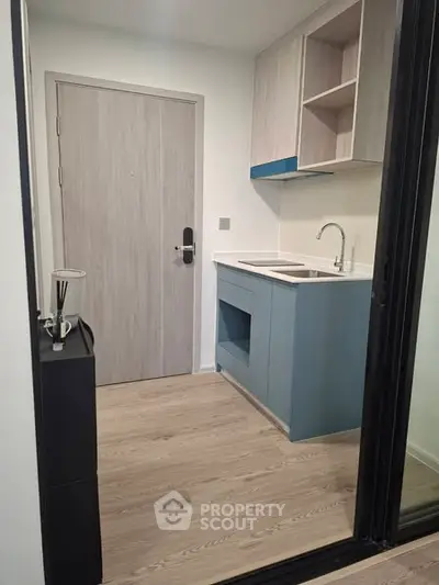 Compact modern kitchen with sleek cabinetry and wooden flooring