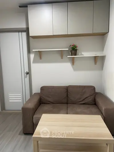 Cozy living room with brown sofa, wooden coffee table, and modern wall shelves.
