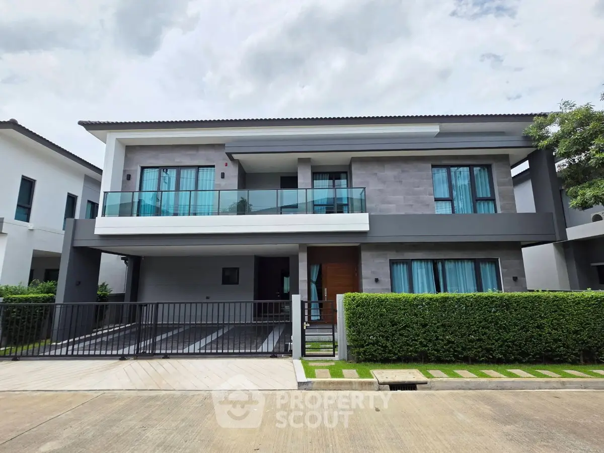 Modern two-story house with sleek design and spacious balcony in a serene neighborhood.