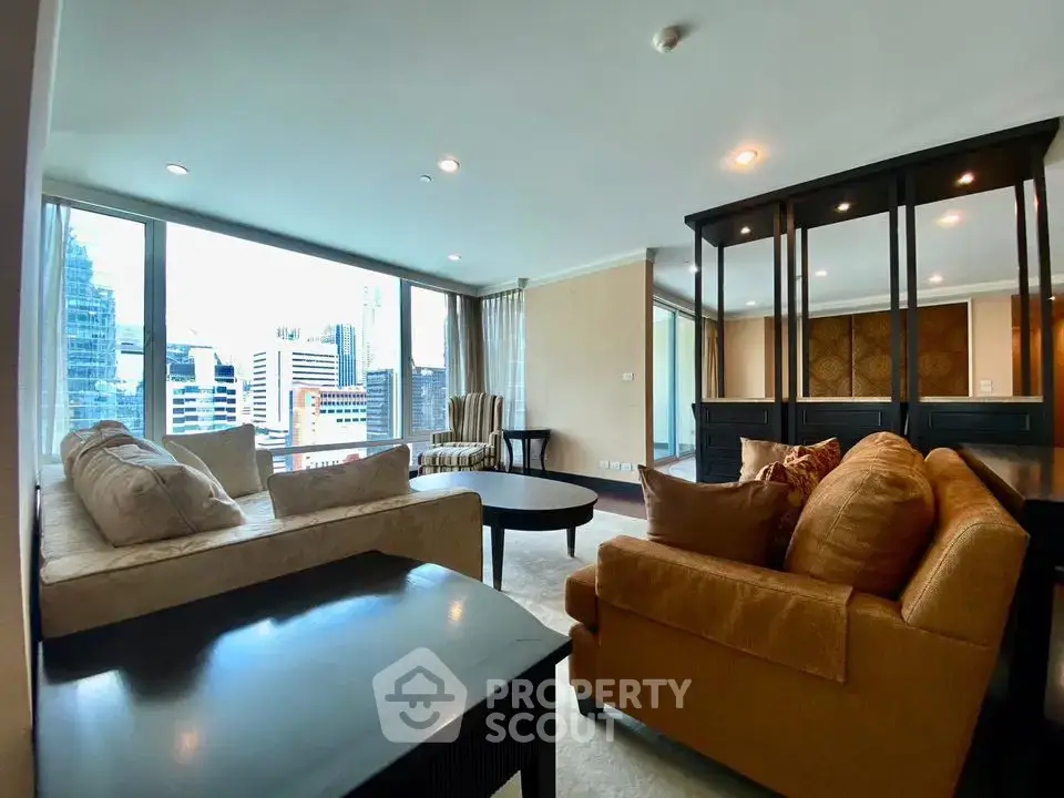 Spacious living room with city view, featuring elegant furniture and large windows.