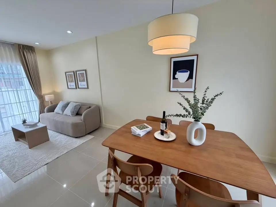 Modern living room with dining area, stylish decor, and natural light.