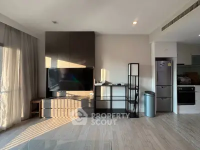 Modern living room with sleek TV setup and open kitchen layout