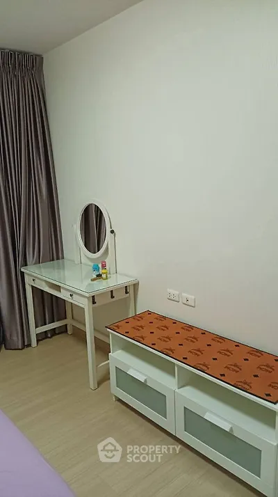 Modern bedroom with stylish vanity and storage bench, perfect for urban living.