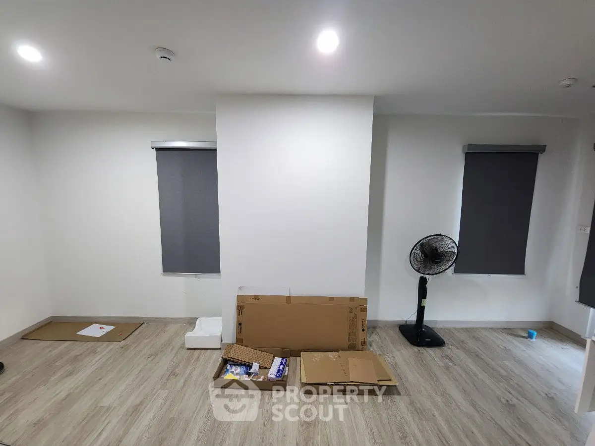 Spacious unfurnished room with wooden flooring and modern blinds, ideal for customization.