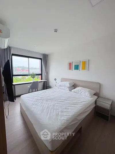 Modern bedroom with large window and minimalist decor in a stylish apartment.