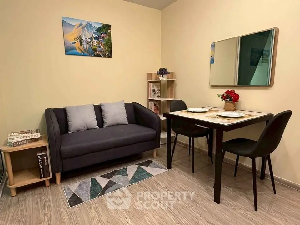 Cozy living room with modern decor, featuring a stylish sofa, dining table, and elegant wall art.