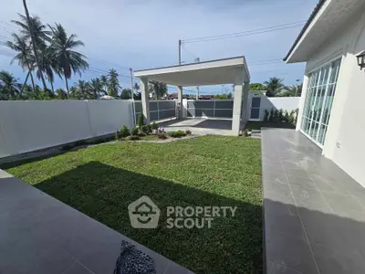 Spacious backyard with covered patio and lush green lawn in modern home