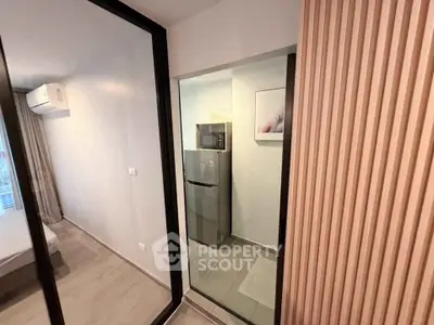 Modern apartment with sleek kitchen featuring stainless steel appliances and stylish design.