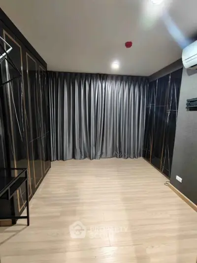 Spacious modern room with elegant curtains and sleek flooring, perfect for versatile use.