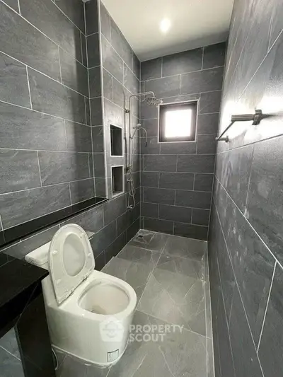 Modern bathroom with sleek gray tiles and contemporary fixtures.