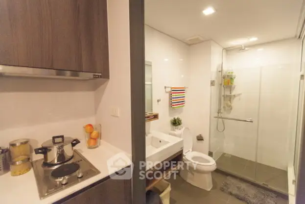 Modern bathroom with glass shower and compact kitchen area