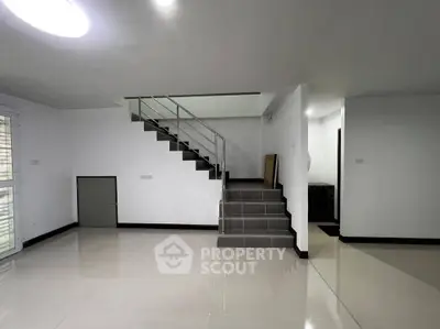 Spacious modern interior with sleek staircase and glossy tiled flooring, perfect for contemporary living.