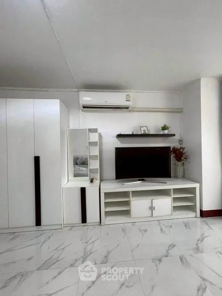 Modern living room with sleek white furniture and marble flooring