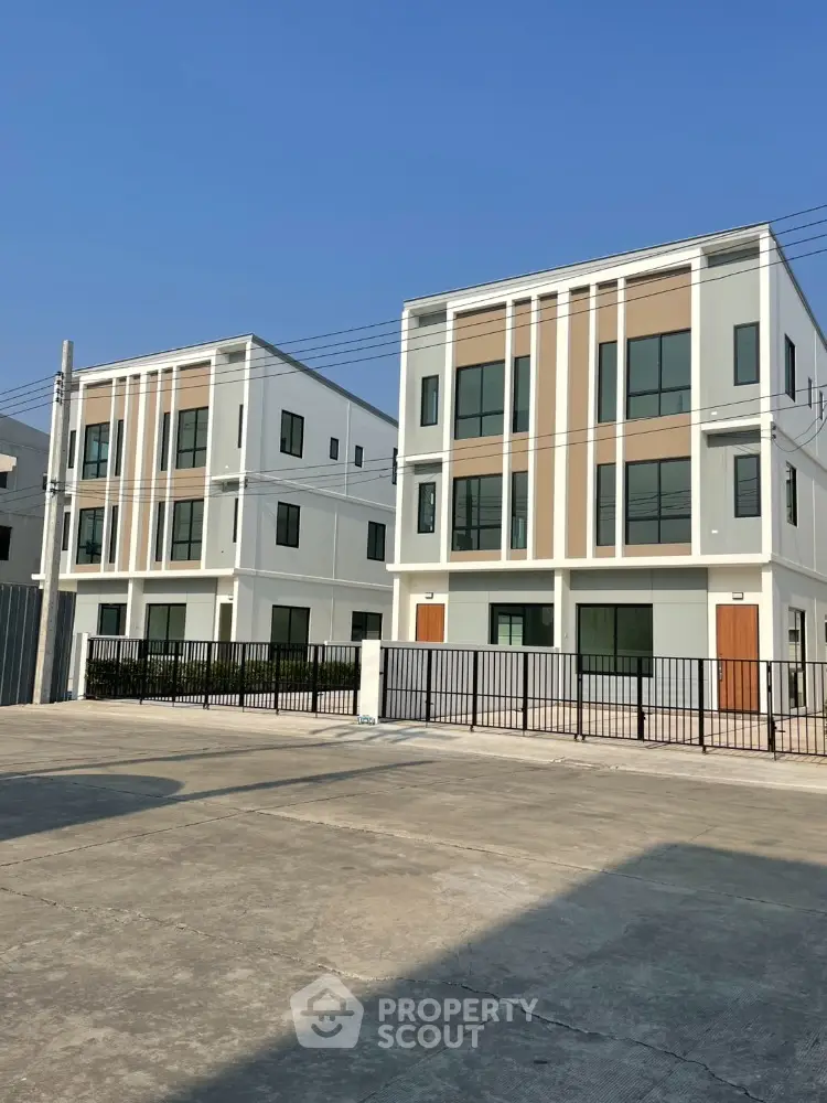 Modern three-story townhouses with sleek design and ample parking space
