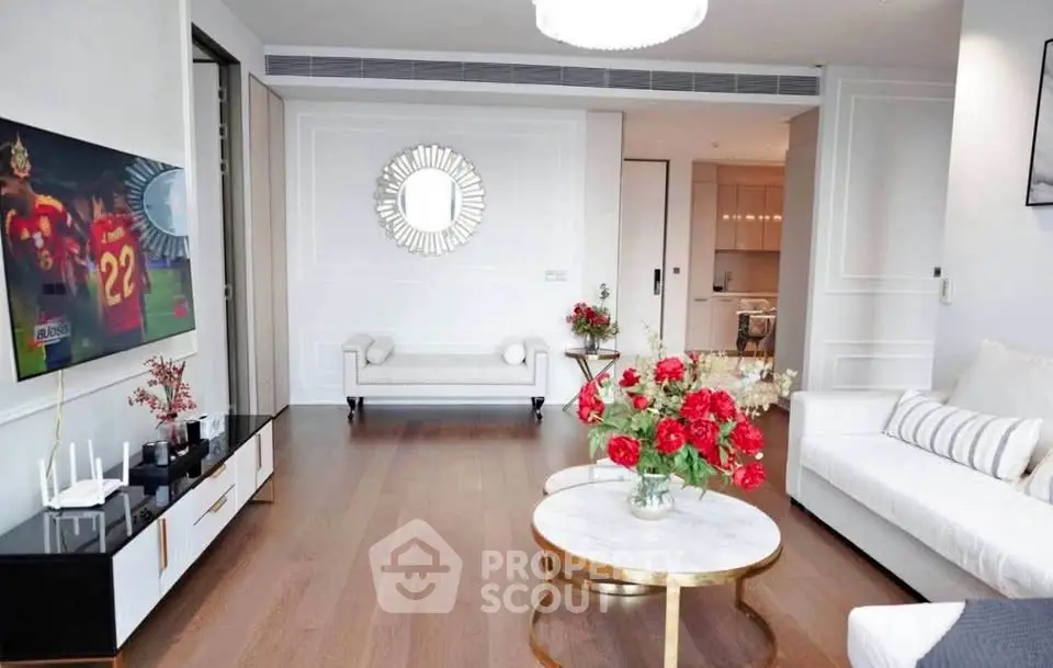Elegant living room with modern decor and hardwood floors, featuring a stylish coffee table and wall mirror.