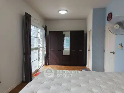 Spacious bedroom with large wardrobe and natural light through window