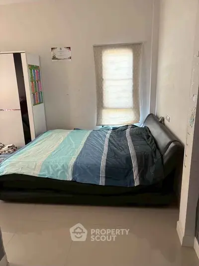 Cozy bedroom with modern bed and window shade, perfect for restful nights.