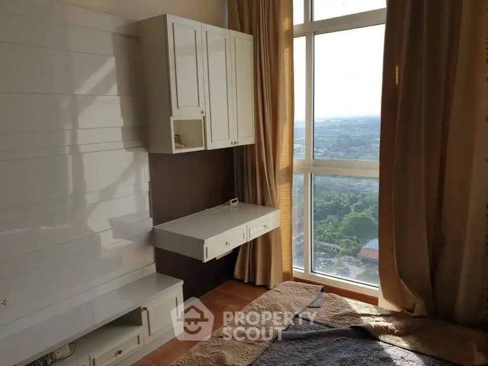 Bright bedroom with large window offering stunning city view, featuring modern built-in furniture and cozy decor.