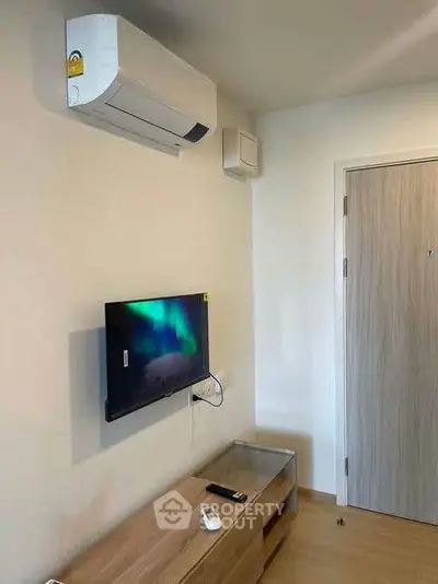 Modern living room with wall-mounted TV and air conditioning unit, showcasing sleek design and comfort.