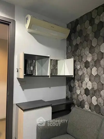 Modern living room with stylish hexagonal wall design and sleek furniture