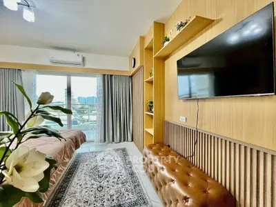 Modern living room with TV, stylish decor, and balcony view