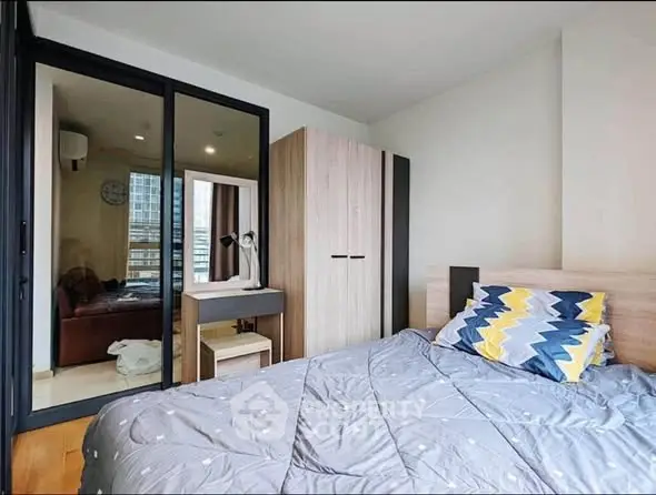 Modern bedroom with stylish decor and ample natural light in urban apartment.