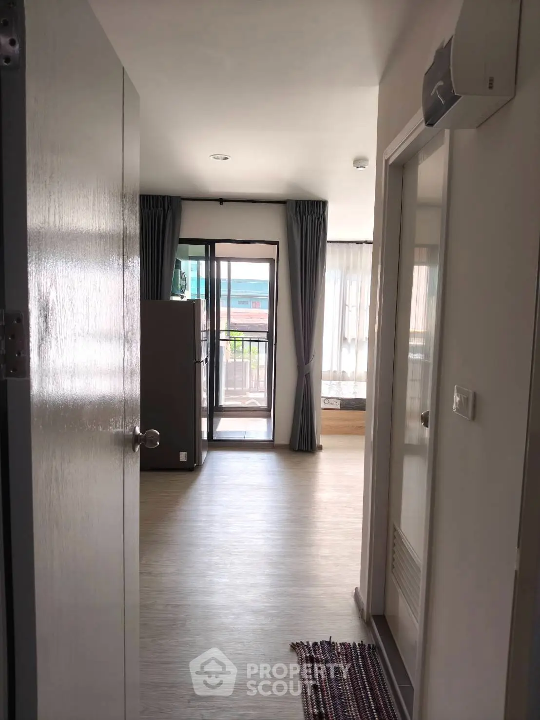 Bright and airy apartment entrance with view of balcony and modern interior design.