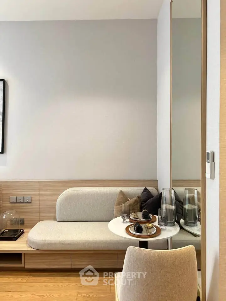 Modern living room with stylish furniture and elegant decor, featuring a cozy seating area and sleek wooden flooring.