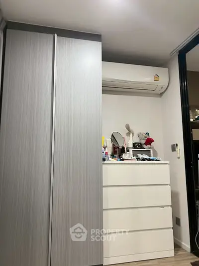 Modern bedroom with sleek wardrobe and air conditioning unit