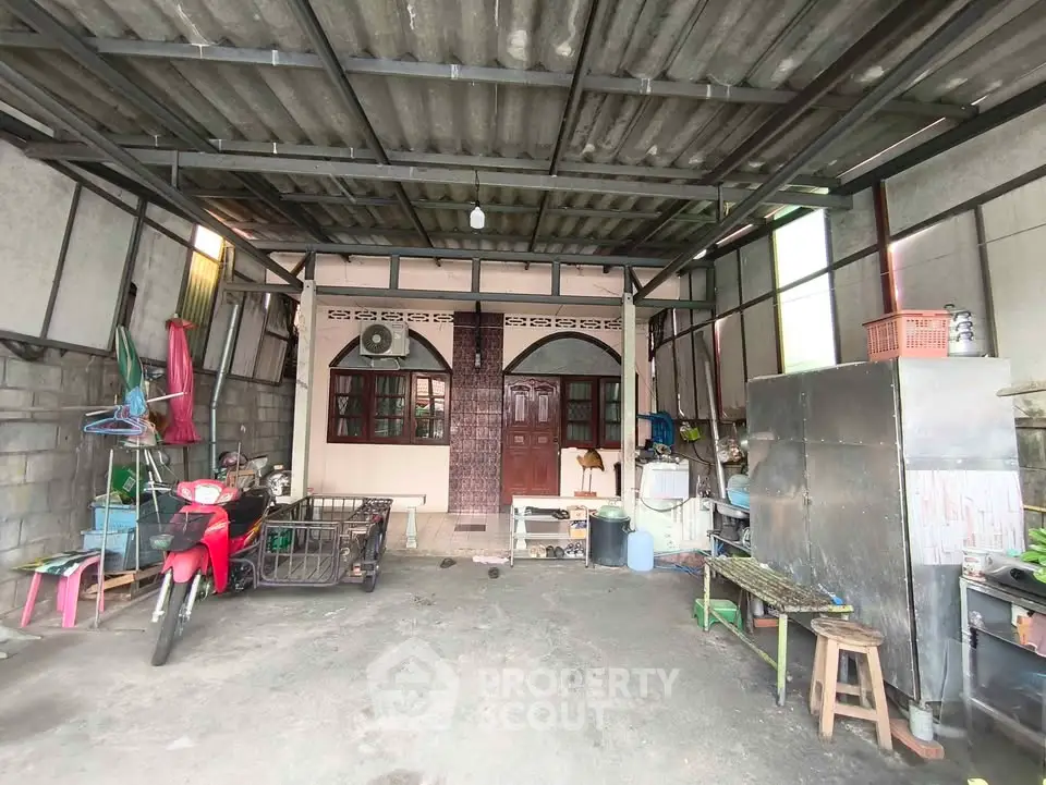 Spacious covered garage with motorbike parking and storage area in a residential property.