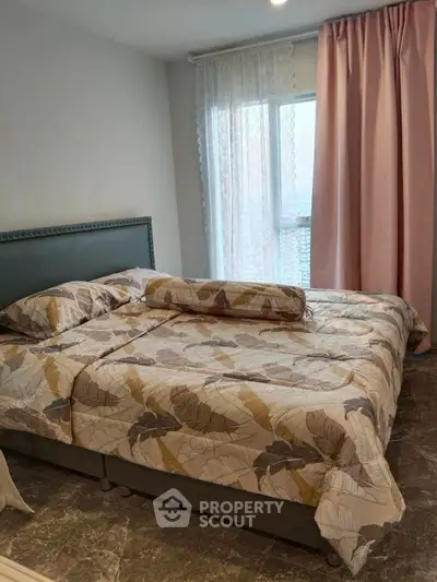 Cozy bedroom with stylish decor and large window for natural light.