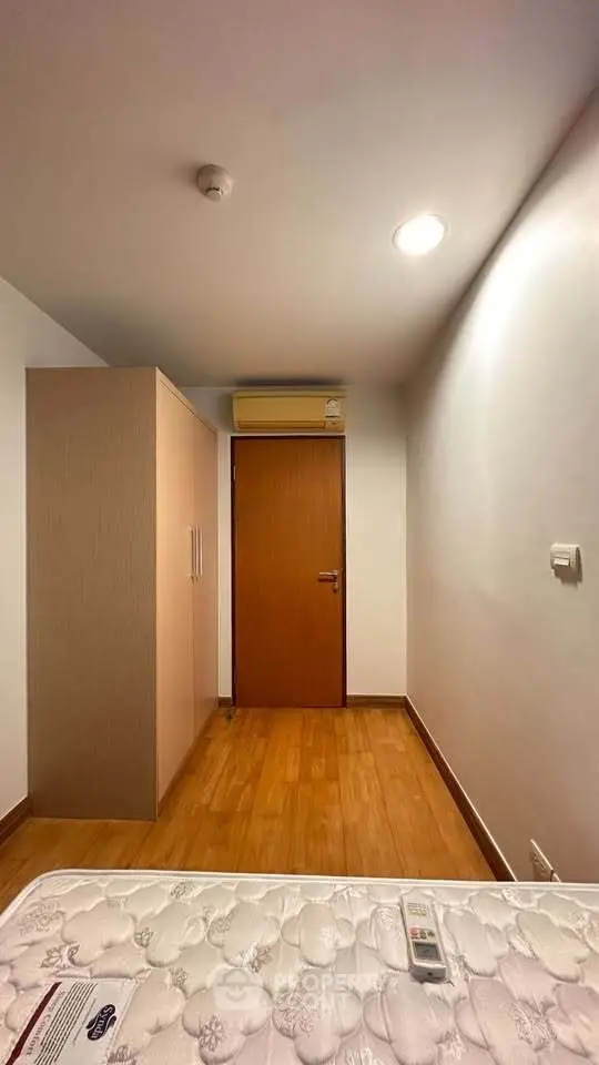 Cozy bedroom with wooden flooring and built-in wardrobe, perfect for a minimalist lifestyle.