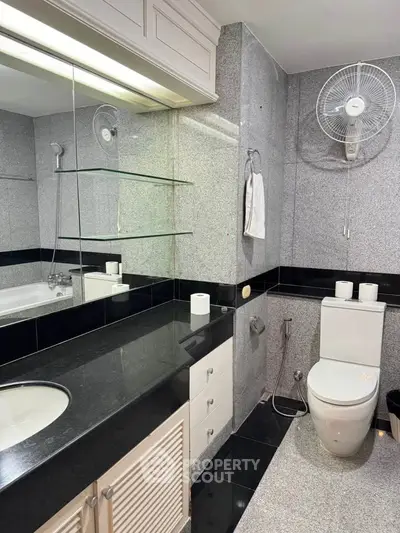 Modern bathroom with sleek black and white design, featuring a bathtub and elegant fixtures.