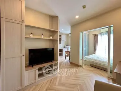 Modern apartment interior with cozy living area and bedroom, featuring stylish wooden flooring and natural light.