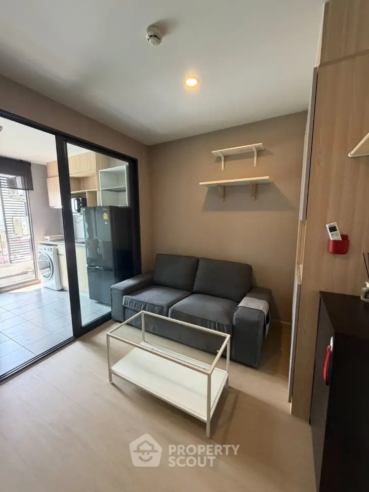 Modern living room with cozy sofa and open kitchen layout in stylish apartment.