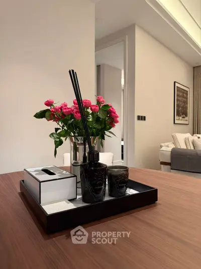 Elegant living room with stylish decor and fresh flowers on a wooden table.