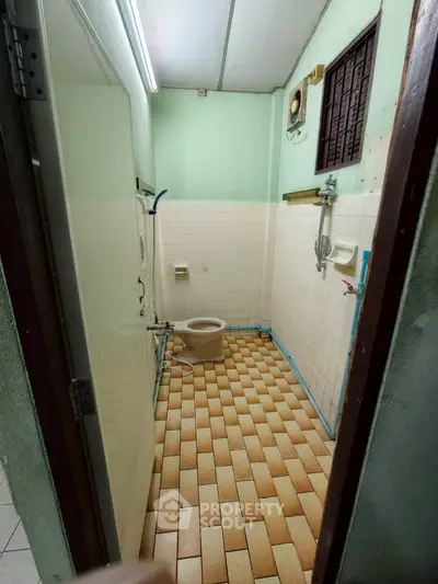 Compact bathroom with vintage tiles and basic fixtures, ideal for budget-friendly renovations.