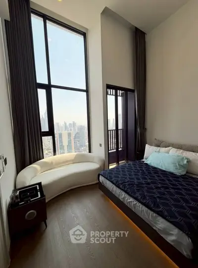 Luxurious bedroom with floor-to-ceiling windows and stunning city view