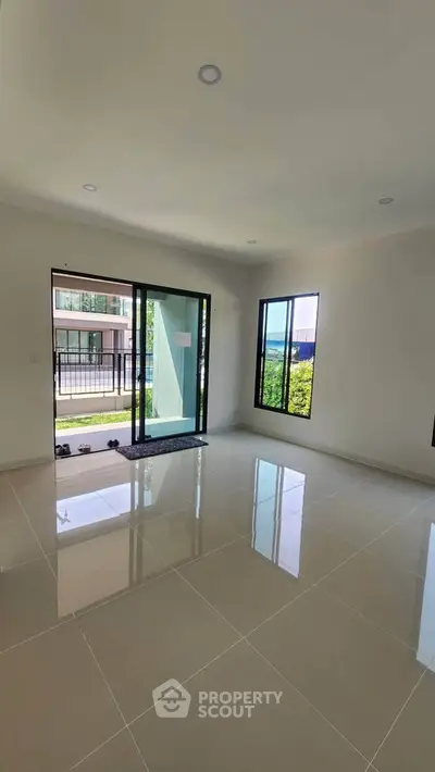 Spacious modern living room with large windows and glossy tiled floor