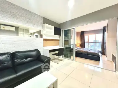 Modern apartment with stylish living room and cozy bedroom, featuring sleek furniture and city view.