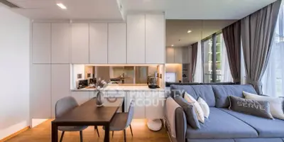 Modern open-plan living room with sleek kitchen and cozy dining area in a stylish apartment.