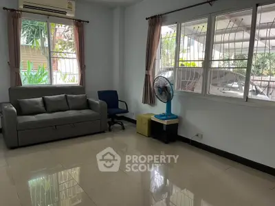 Spacious living room with modern sofa and garden view, perfect for relaxation.